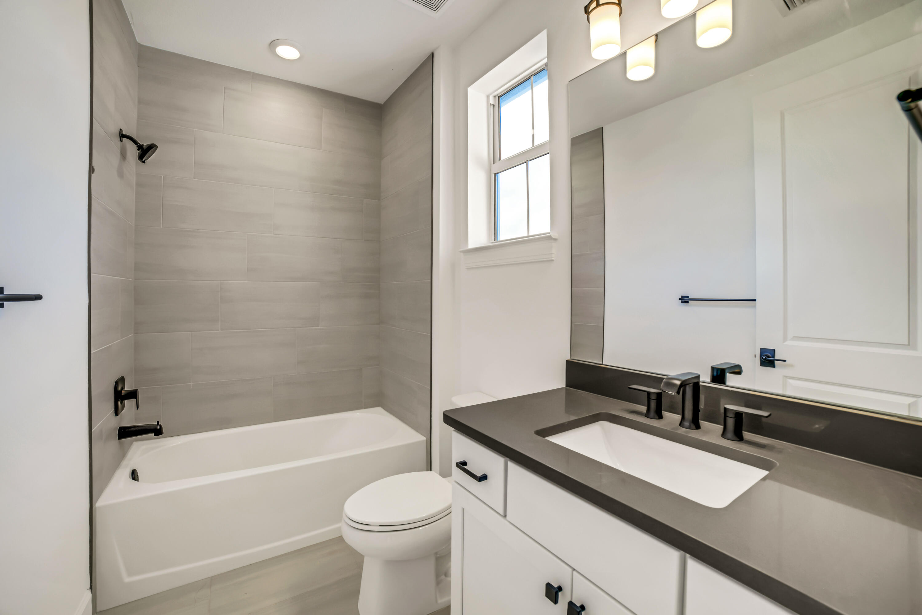 20161 Southeast Bridgewater Drive Jupiter, FL 33458 - Photo 44 of 50 a bathroom with a sink a toilet a mirror a bathtub and shower