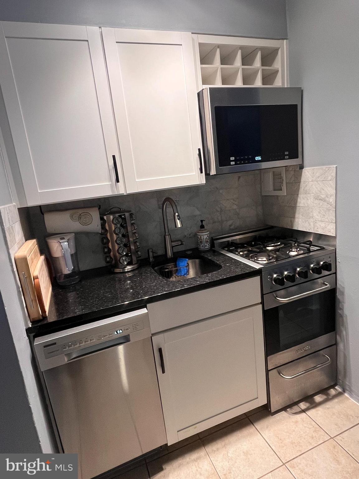 2101-17 Chestnut Street, Unit 319 Philadelphia, PA 19103 - Photo 14 of 33 a kitchen with granite countertop a stove and a microwave