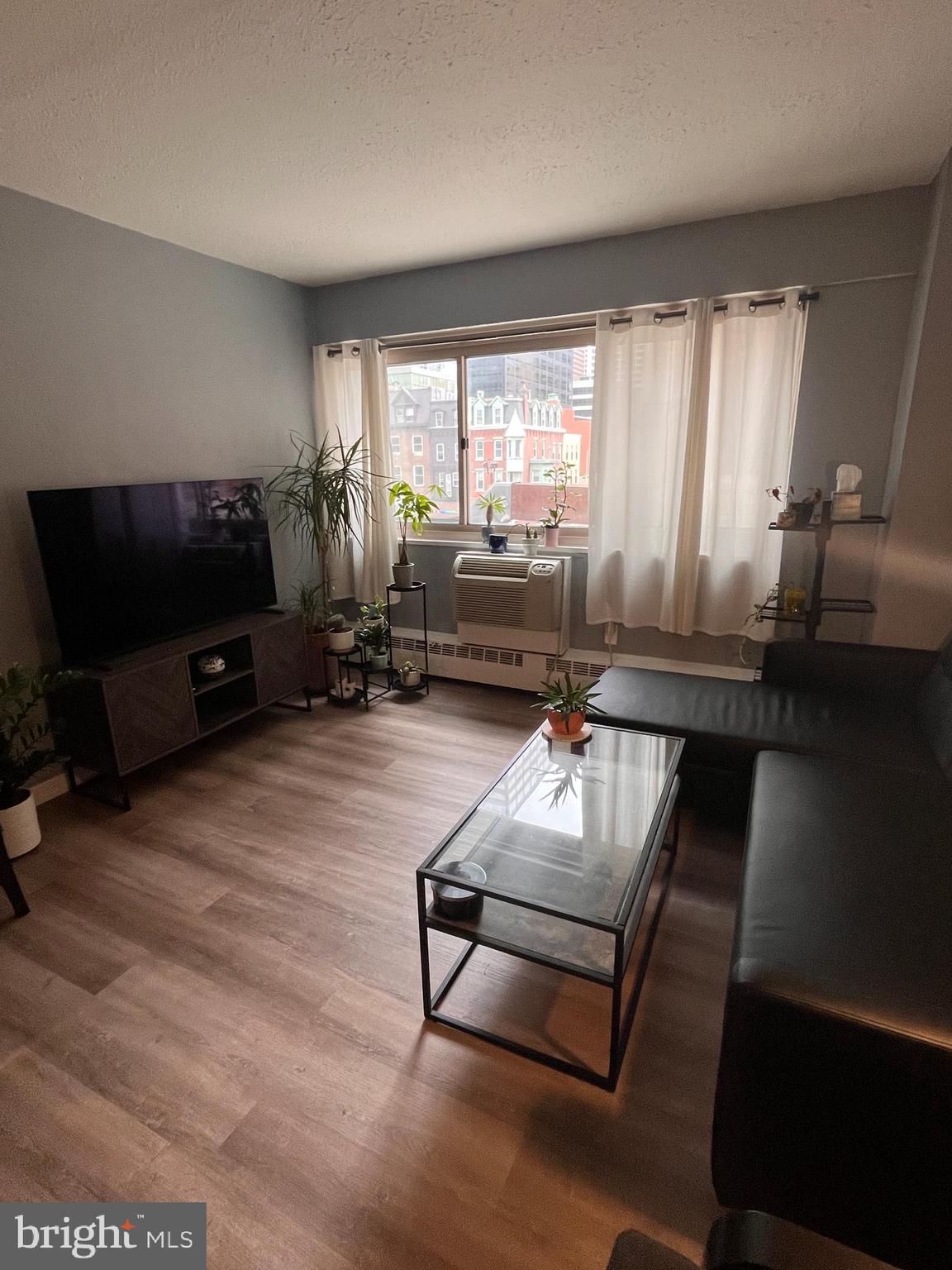 2101-17 Chestnut Street, Unit 319 Philadelphia, PA 19103 - Photo 5 of 33 a living room with furniture and a flat screen tv