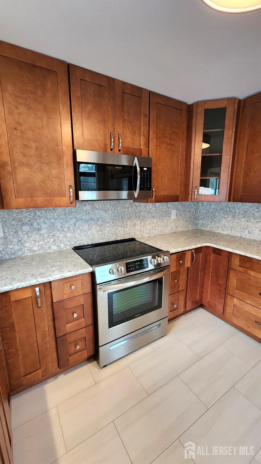838 Vail Road, Unit A Monroe Township, NJ 08831 - Photo 7 of 34 a kitchen with stainless steel appliances granite countertop a stove a sink and a microwave
