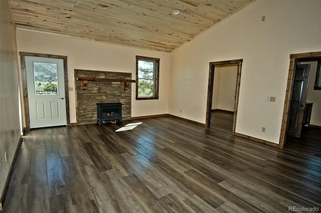 a view of empty room with wooden floor and fireplace