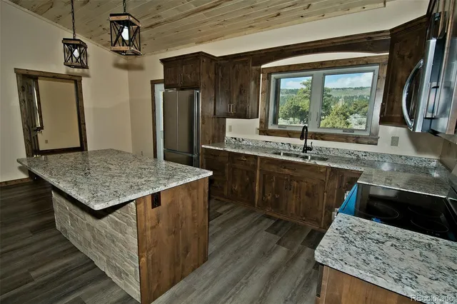 a kitchen with kitchen island a sink stove and refrigerator