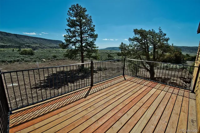 a view of balcony with wooden floor and fence