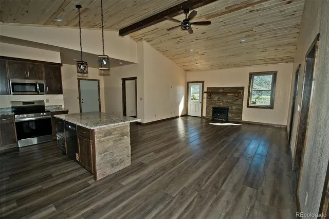 a large kitchen with stainless steel appliances granite countertop a stove and a wooden floors