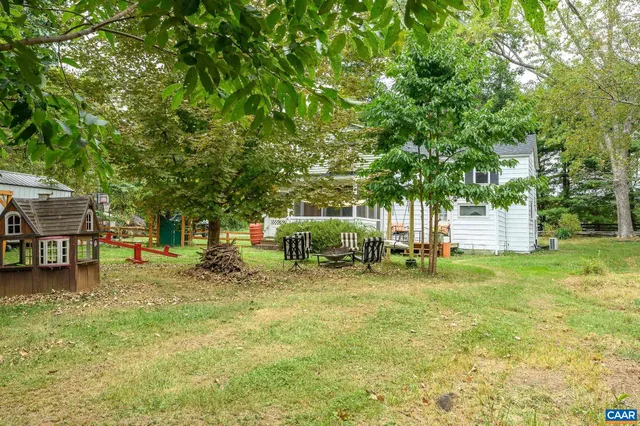 a backyard of a house with table and chairs