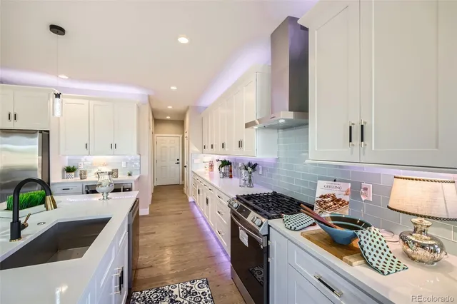 a kitchen with stainless steel appliances granite countertop a sink stove and refrigerator