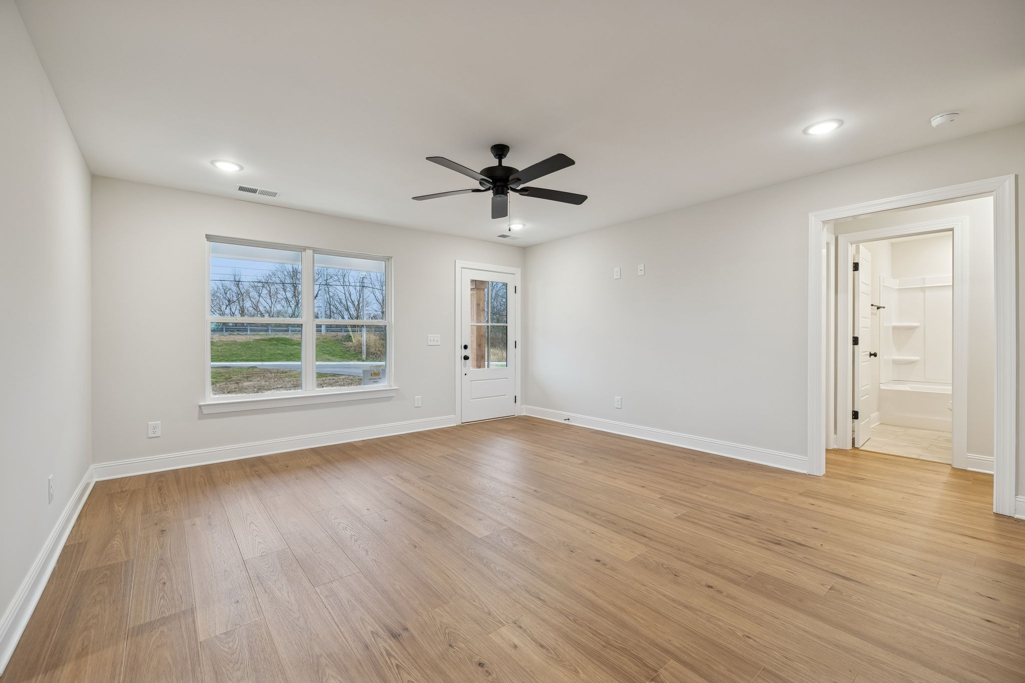 1057 Landing Lane Adams, TN 37010 - Photo 7 of 29 an empty room with wooden floor and windows