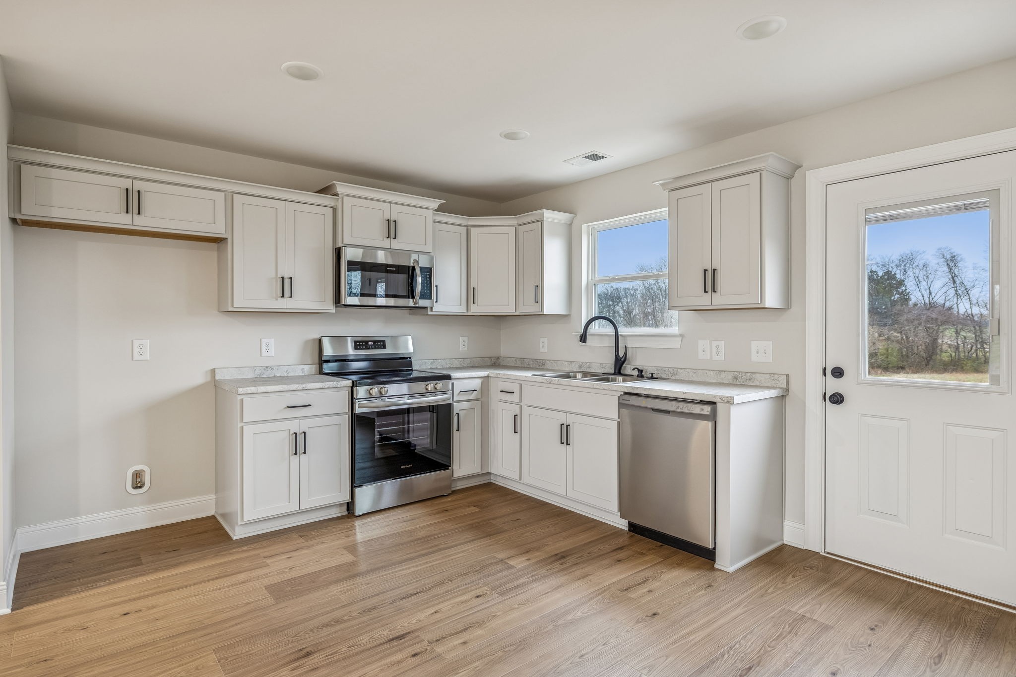1057 Landing Lane Adams, TN 37010 - Photo 8 of 29 a kitchen with granite countertop white cabinets and stainless steel appliances