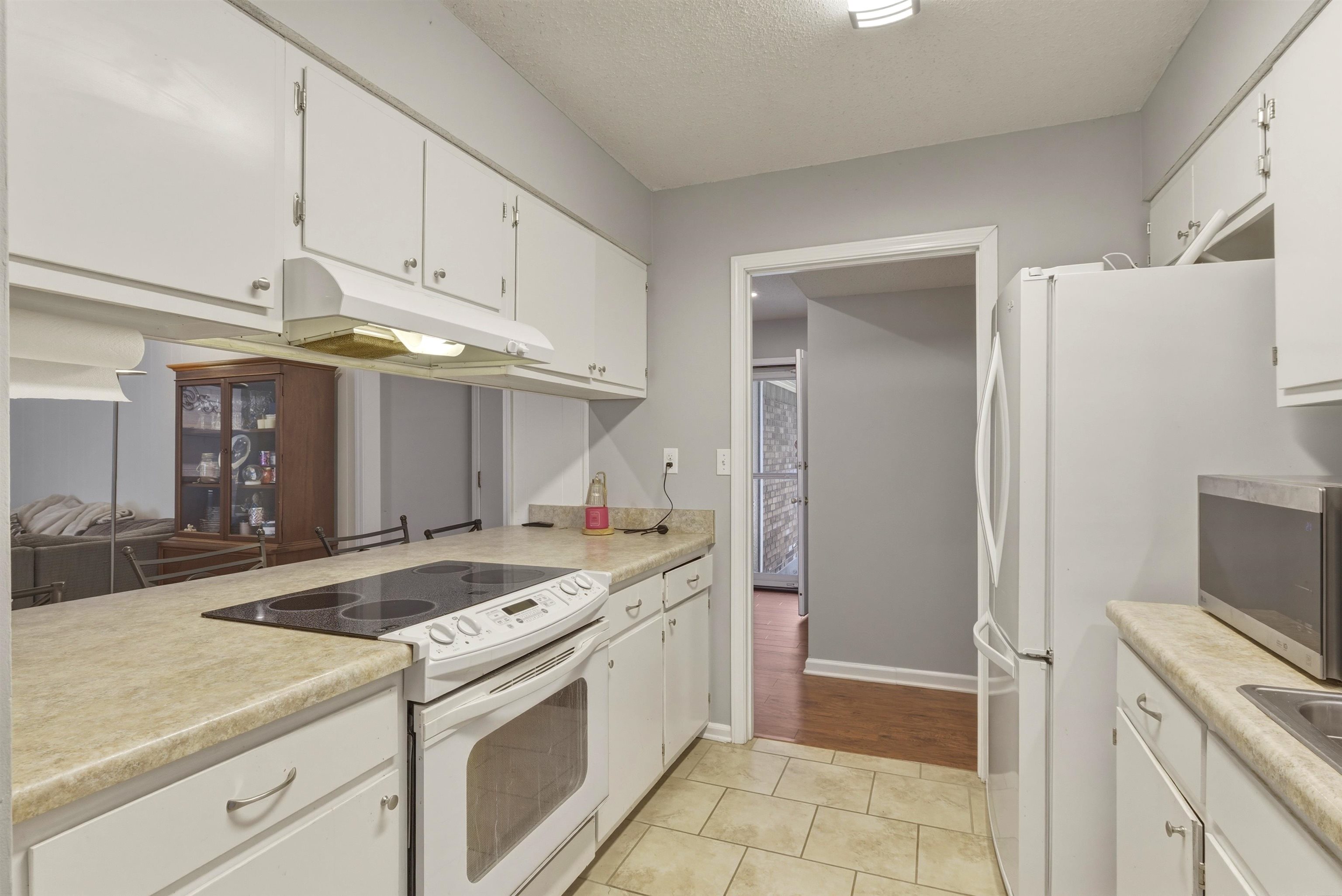 3276 Altruria Road Bartlett, TN 38134 - Photo 8 of 30 Kitchen featuring extensive white cabinetry, a built-in electric cooktop, light-toned countertops, and tile flooring