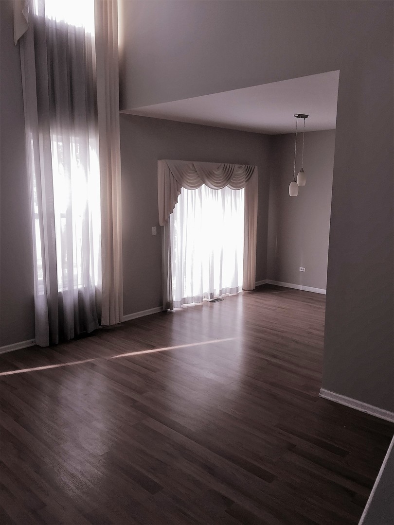 1499 Keystone Court, Unit 423 Elgin, IL 60120 - Photo 3 of 18 an empty room with wooden floor and windows