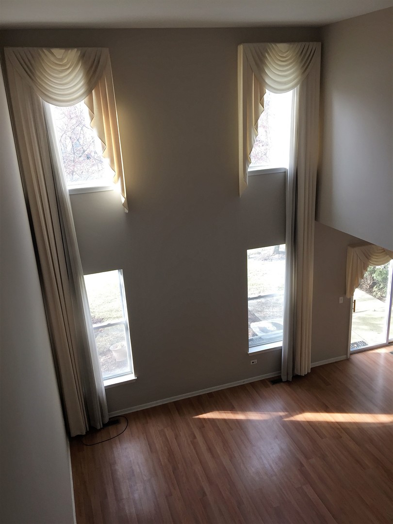1499 Keystone Court, Unit 423 Elgin, IL 60120 - Photo 8 of 18 an empty room with wooden floor and windows