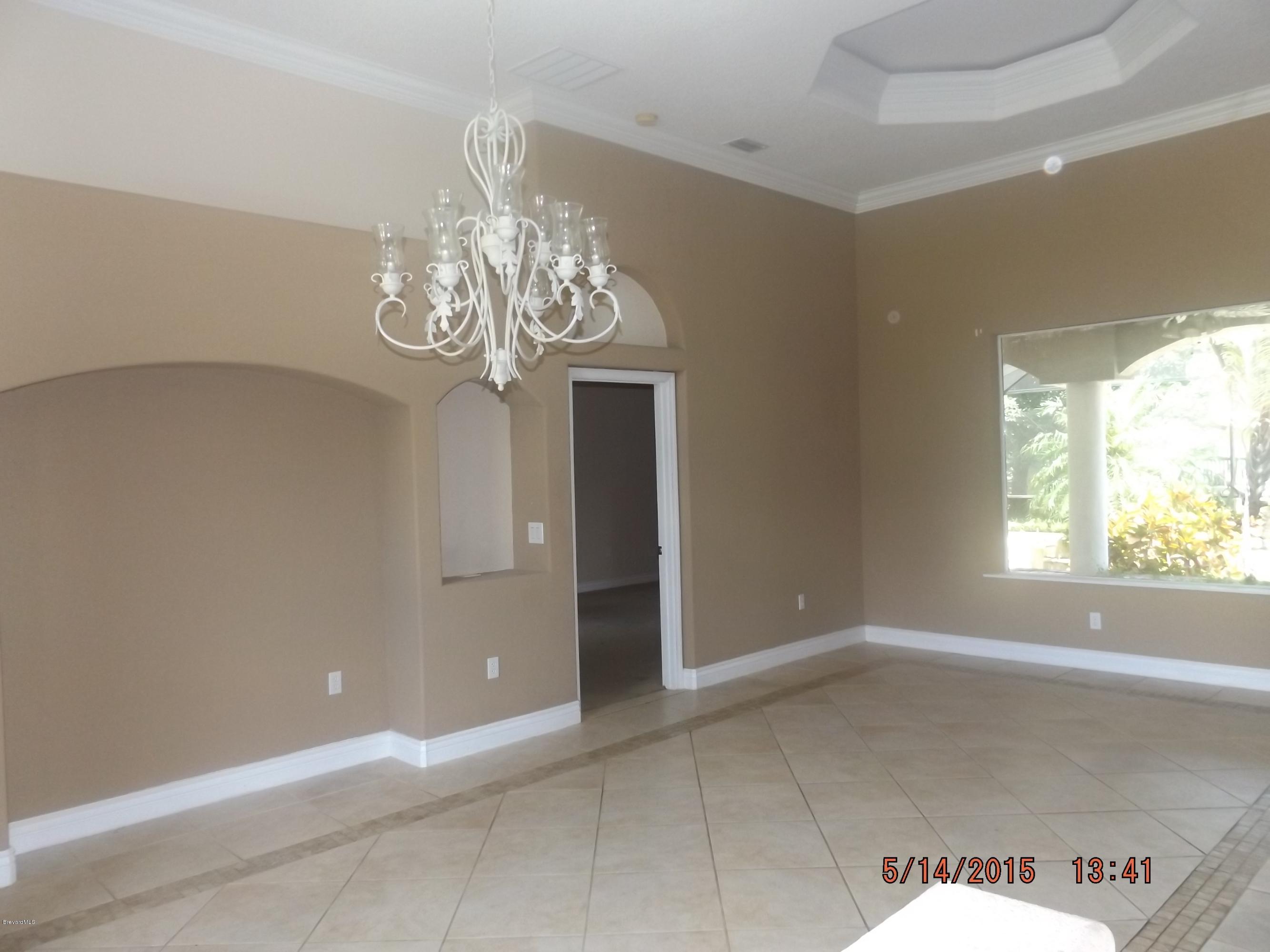 3201 Aurora Road Melbourne, FL 32934 - Photo 2 of 18 en empty room with windows and chandelier