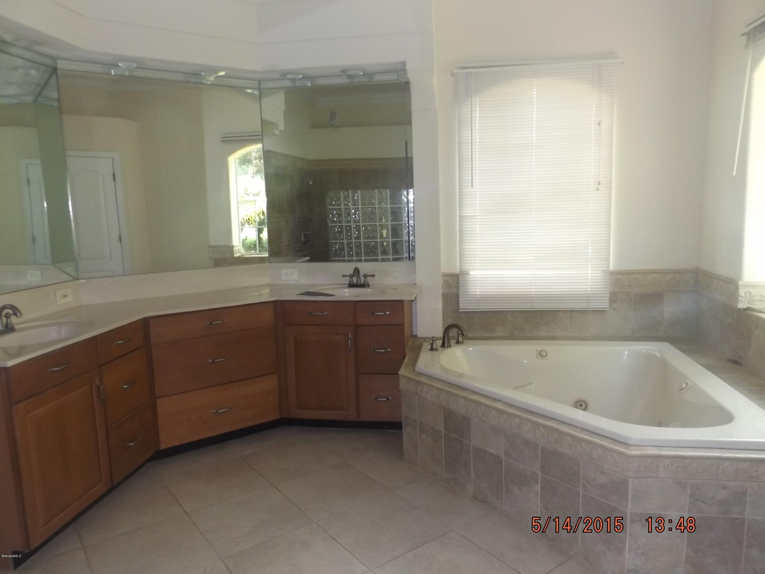 3201 Aurora Road Melbourne, FL 32934 - Photo 9 of 18 a spacious bathroom with a tub sink and mirror