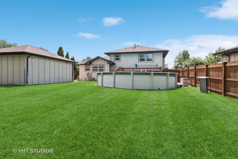 a front view of a house with a yard and deck