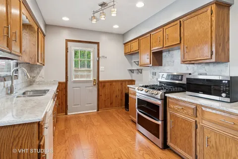 a kitchen with stainless steel appliances granite countertop a sink stove and refrigerator