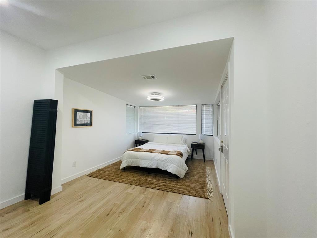 1403 Newfield Lane Austin, TX 78703 - Photo 15 of 34 a bedroom with a bed and a black wall painting