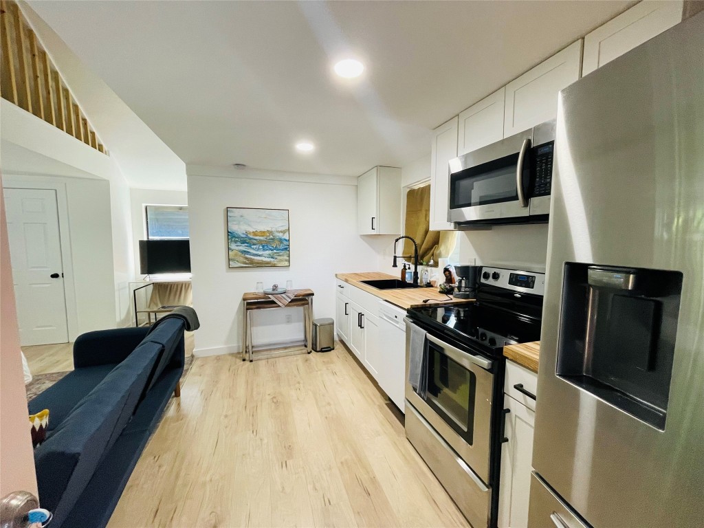 1403 Newfield Lane Austin, TX 78703 - Photo 20 of 34 a kitchen with stainless steel appliances a refrigerator a stove a microwave and cabinets