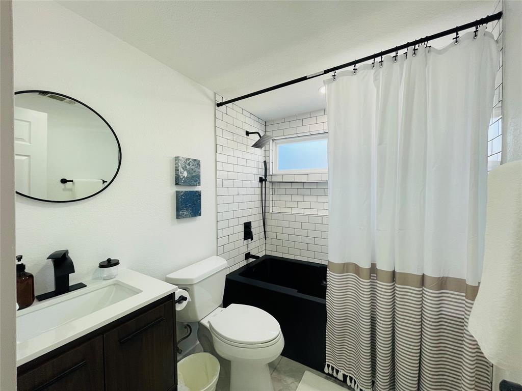 1403 Newfield Lane Austin, TX 78703 - Photo 21 of 34 a bathroom with a sink toilet a mirror and shower curtain