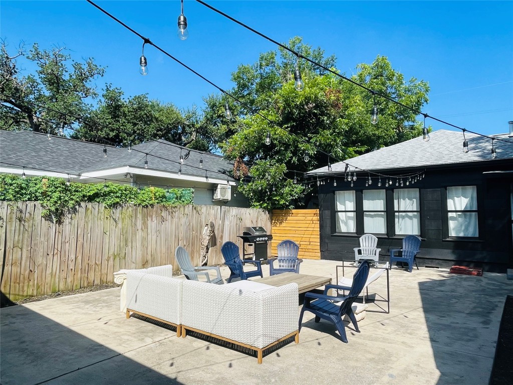 1403 Newfield Lane Austin, TX 78703 - Photo 32 of 34 a view of a patio with couches table and chairs under an umbrella with a small yard