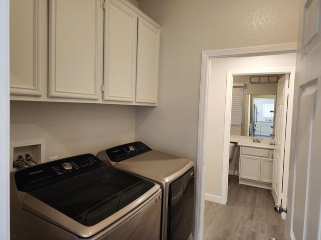 a view of kitchen stove and white cabinets