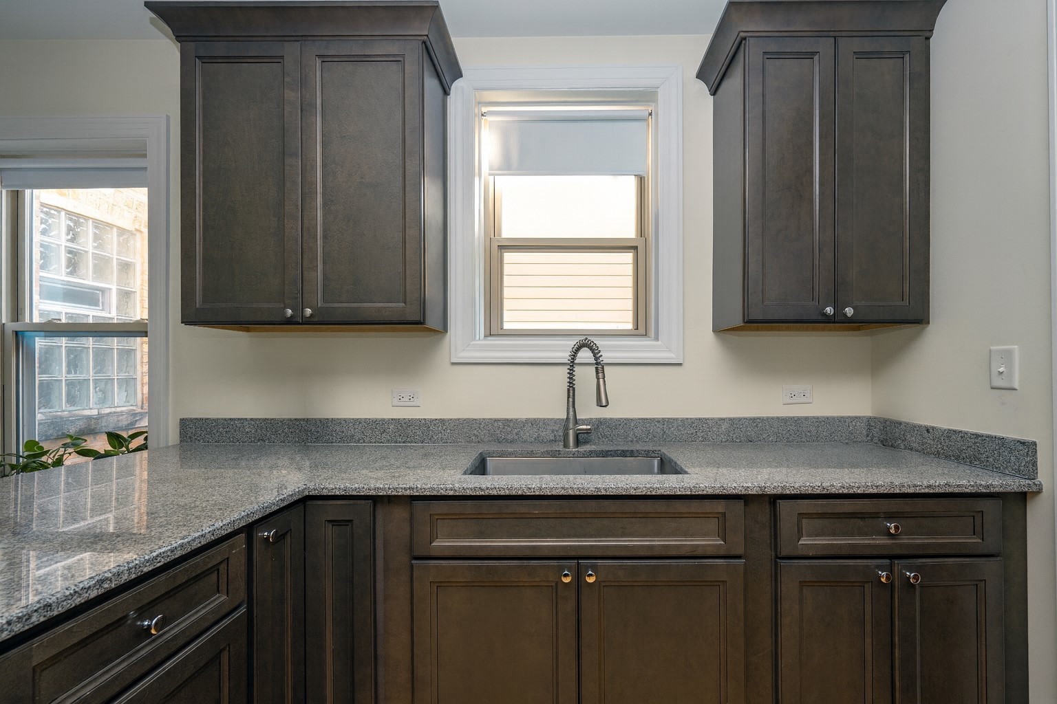 5501 West School Street, Unit 1C Chicago, IL 60641 - Photo 3 of 11 a kitchen with granite countertop cabinets sink and window