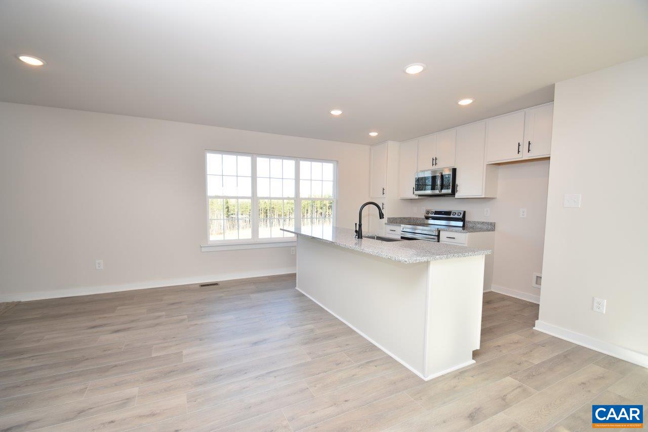 71 Riva Way Palmyra, VA 22963 - Photo 7 of 26 a kitchen with stainless steel appliances kitchen island granite countertop a stove a sink a refrigerator and white cabinets with wooden floor