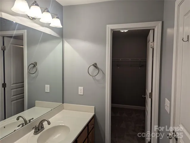 a bathroom with a sink vanity granite and a mirror