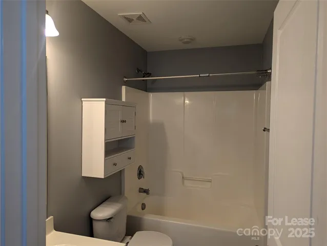 a bathroom with a shower a toilet and a sink