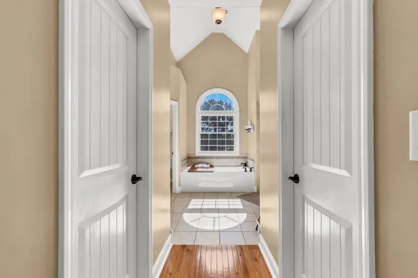 a view of a hallway with wooden floor and furniture
