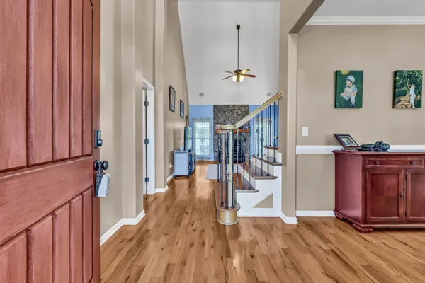 a view of a hallway with wooden floor and staircase