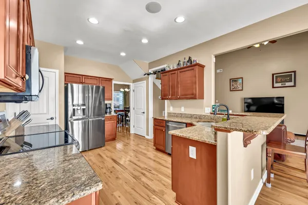 a large kitchen with stainless steel appliances granite countertop a sink stove and refrigerator