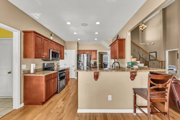a view of a kitchen with kitchen island stainless steel appliances refrigerator stove microwave and cabinets