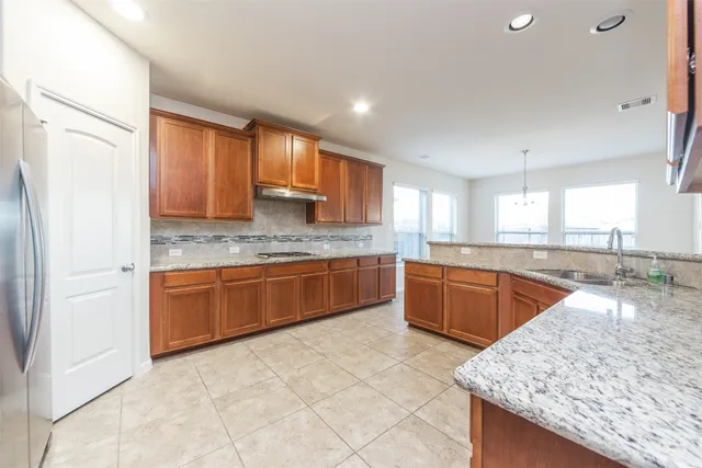 a large kitchen with kitchen island granite countertop wooden cabinets a granite counter tops and a white stove