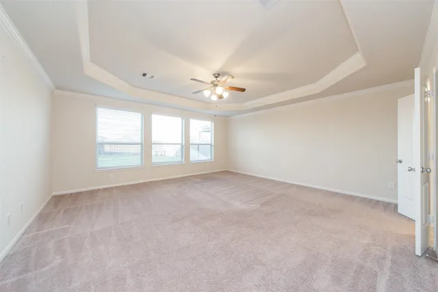 an empty room with windows and ceiling fan
