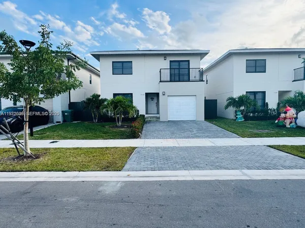 a front view of a house with a yard and a garage