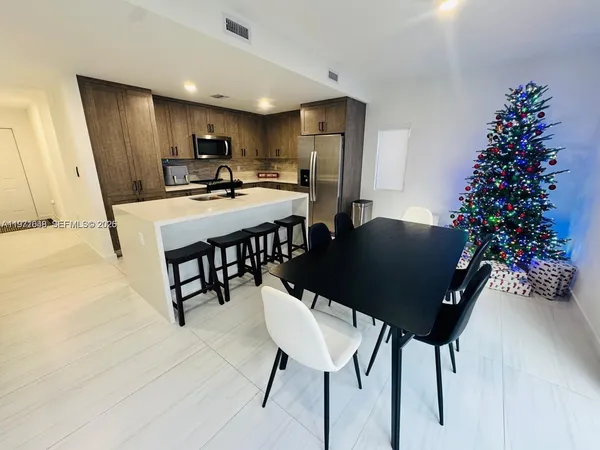 a kitchen with stainless steel appliances a sink stove refrigerator and cabinets