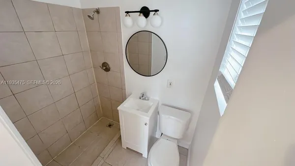 a bathroom with a toilet and a mirror
