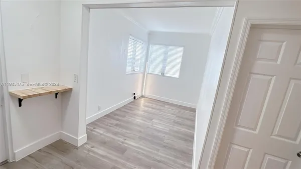 a view of a room that has wooden floor washer and dryer