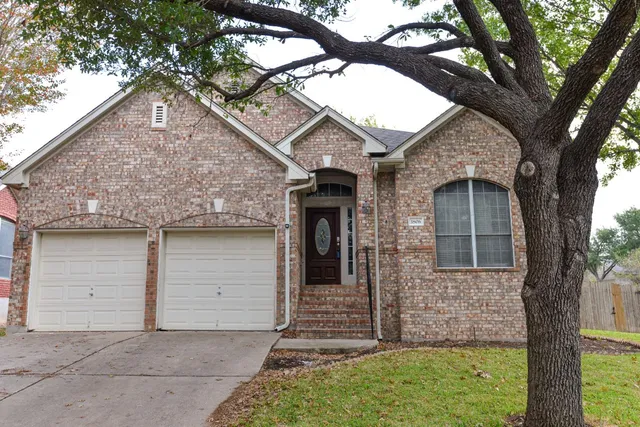 front view of a house with a tree in the yard