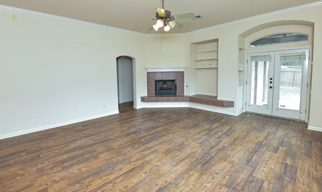 a view of an empty room with a fireplace and a window