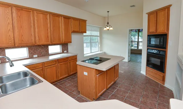 a kitchen with stainless steel appliances granite countertop wooden floors and sink