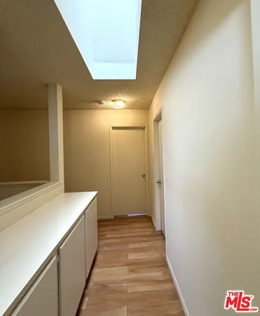 an empty room with wooden floor and mirror