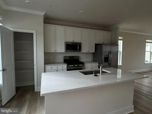 a kitchen with a sink a microwave a refrigerator and cabinets