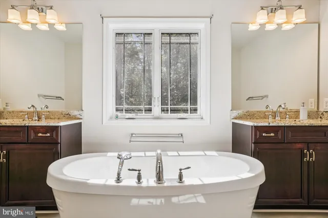 a bathroom with a granite countertop bathtub a sink and a shower