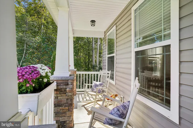 a living room with furniture stairs and a potted plant