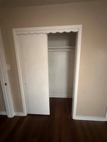 an empty room with wooden floor and closet