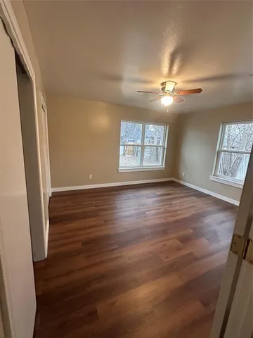 an empty room with wooden floor and closet
