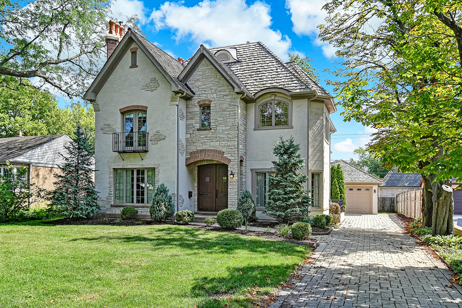 621 North County Line Road Hinsdale, IL 60521 - Photo 1 of 48 a front view of a house with a garden and plants