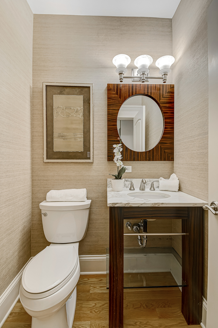 621 North County Line Road Hinsdale, IL 60521 - Photo 17 of 48 a bathroom with a toilet a sink and mirror