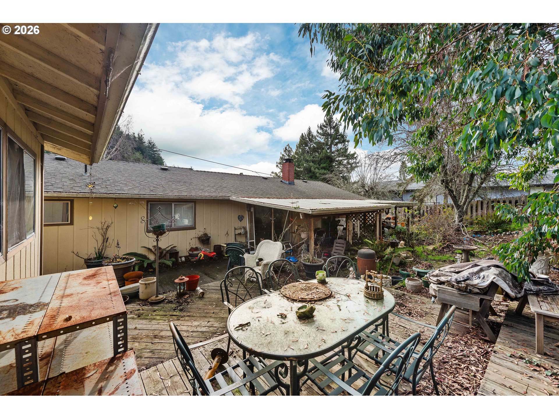 2031 Kincheloe Lane Myrtle Point, OR 97458 - Photo 32 of 33 a view of a patio with table and chairs potted plants with wooden floor